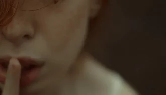 ragazza che pone il dito indice davanti la bocca facendo il cenno del silenzio
